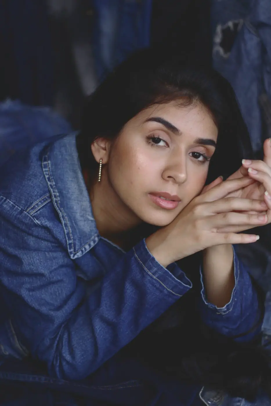 Classic Cool Filmic example: woman in a denim jacket resting her chin on her hands