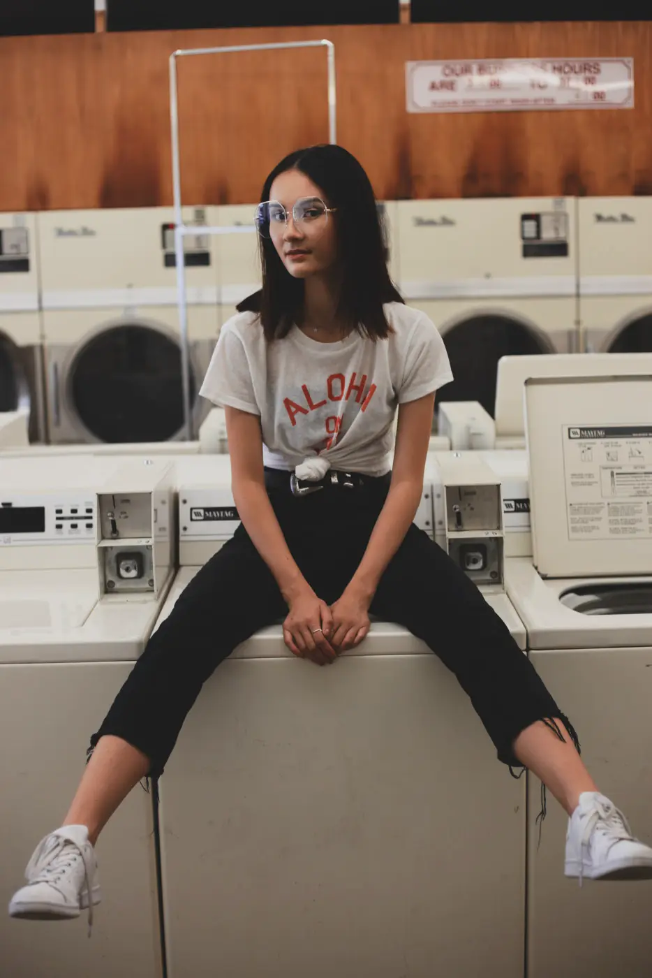 Disposable example: woman sitting on a washing machine in a laundromat